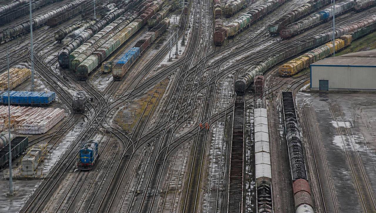 A busy road and rail junction seen from above with traffic crossing.